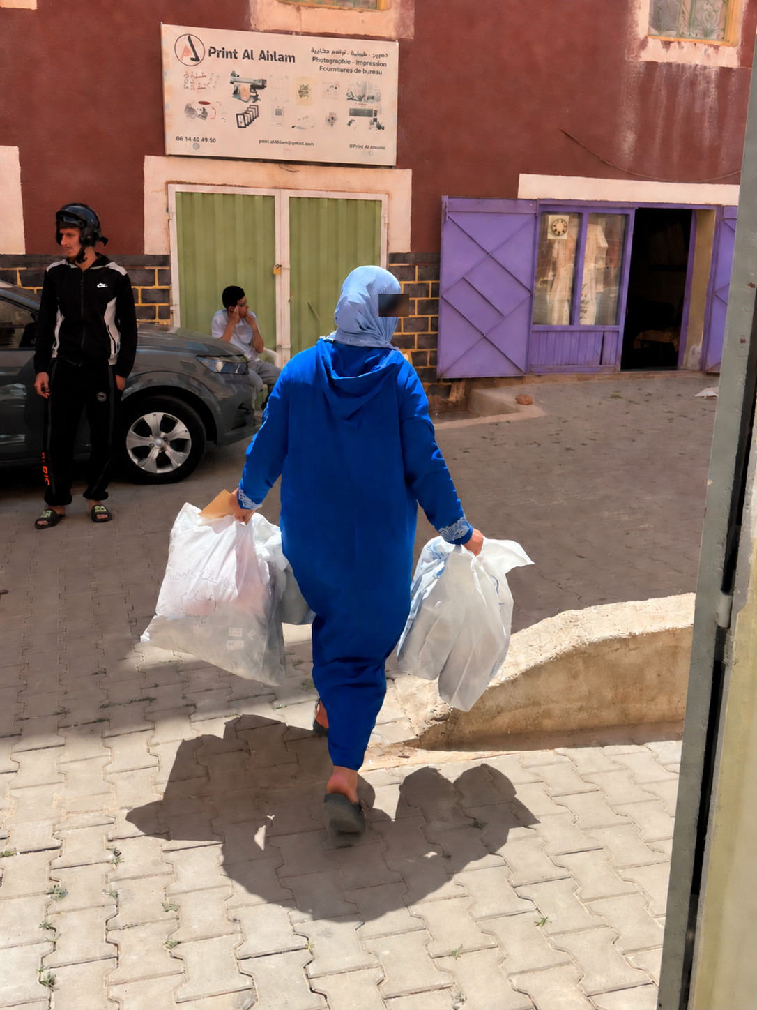مستفيدة تغادر مقر الجمعية ومعها المساعدات